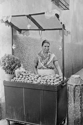 La vendedora ambulante Encarnación Santiago en su puesto de chumbos en Calle Santa María. Agosto de 1954. Málaga. España.